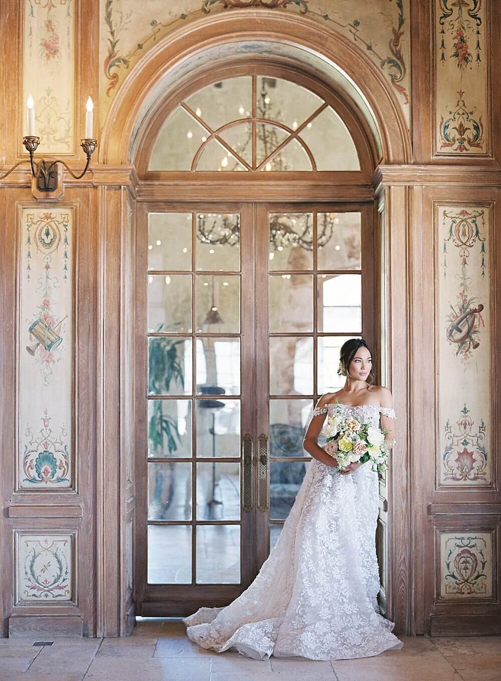 bride leans against French doorway while looking out the window at Cal-a-Vie Spa - Jacqueline Benét