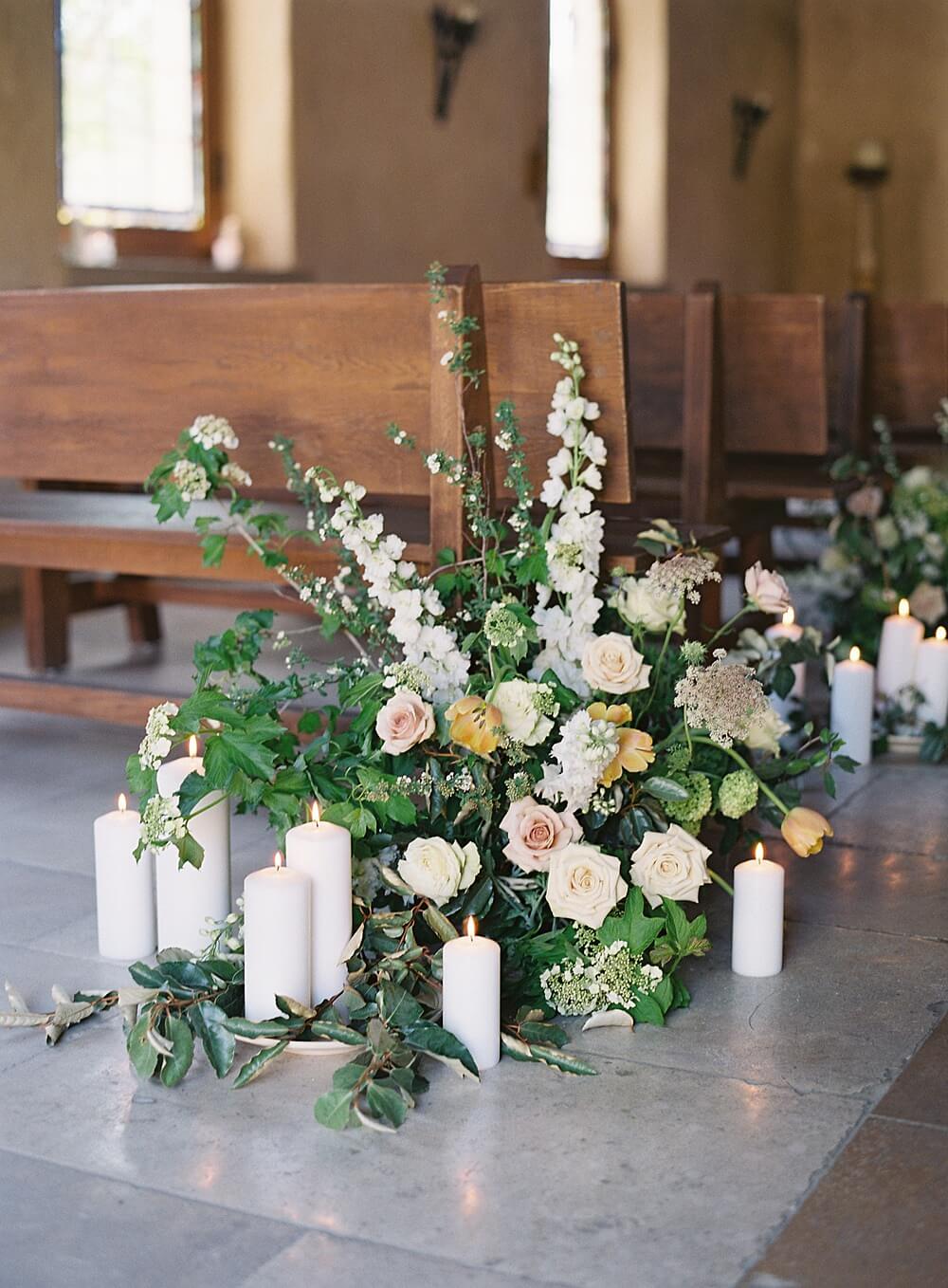 Peach and cream florals line the aisle in the stone chapel at a cal-a-vie wedding - Jacqueline Benét Photography