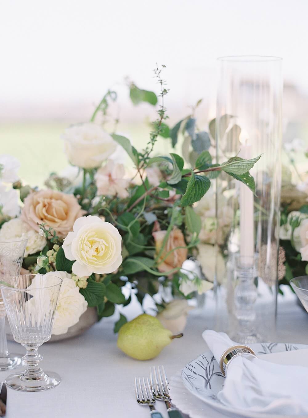 Peach and cream floral arrangement on tabletop with pear detail at cal-a-vie spa wedding - Jacqueline Benét Photography