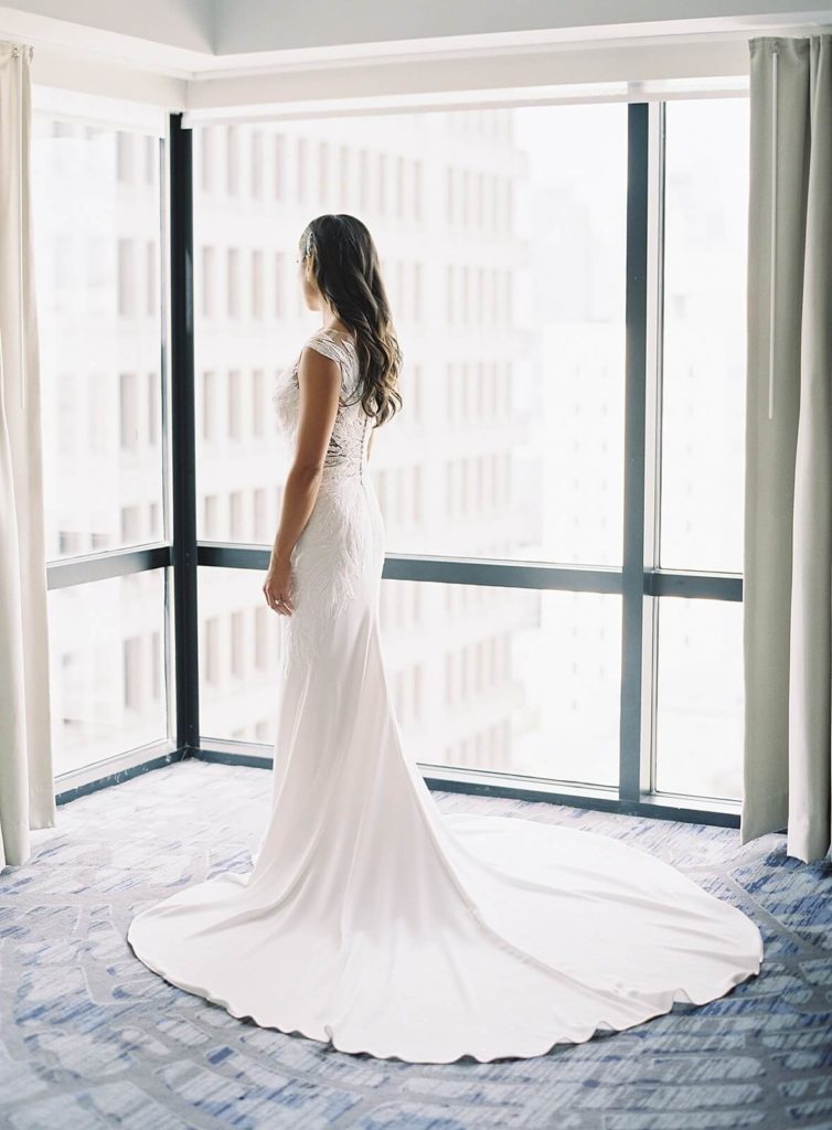 Bride looks out window at Seattle - Jacqueline Benét Photography