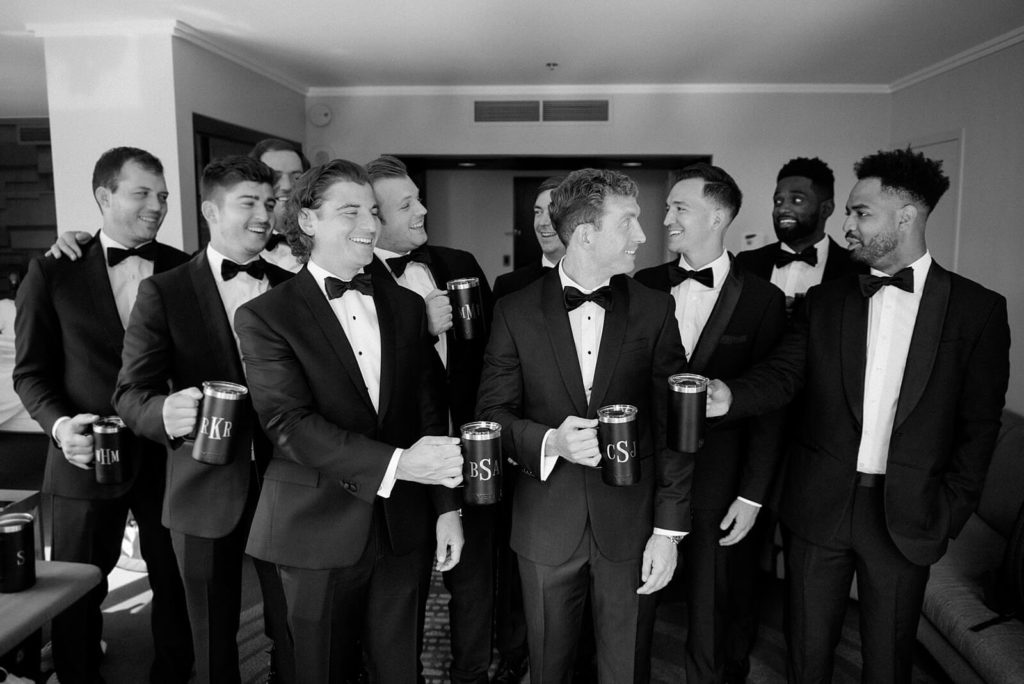 groom with groomsmen cheers with custom growlers - Jacqueline Benét Photography