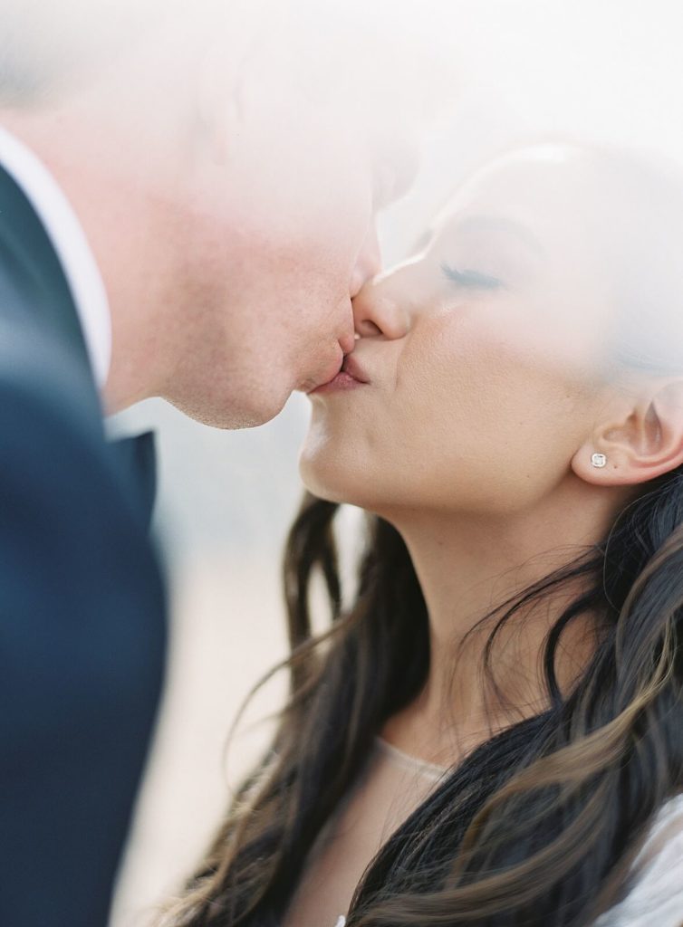 Bride and groom kiss underneath a wedding veil - Jacqueline Benét Photography