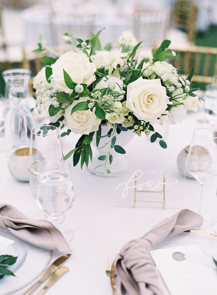 White rose floral centerpiece with clear acrylic table numbers with white calligraphy on wedding tabletop - Jacqueline Benét Photography