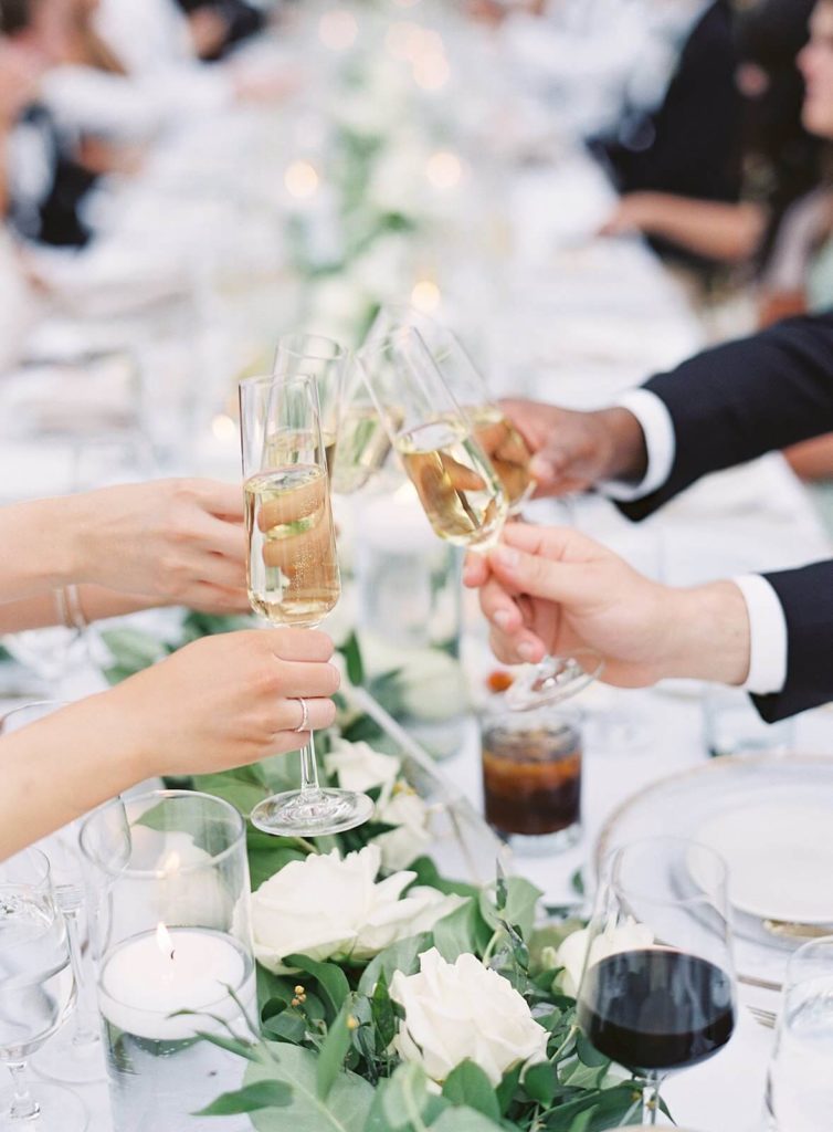 Guests cheers champagne at wedding reception - Jacqueline Benét Photography