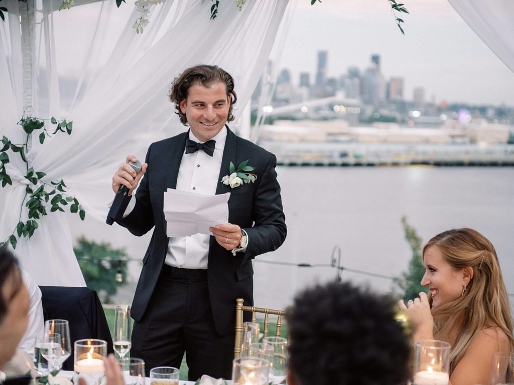 Bestman speech at sunset overlooking Seattle at a wedding reception at Admirals House - Jacqueline Benét Photography