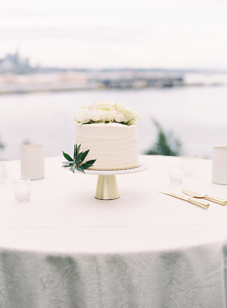White wedding cutting cake overlooking Seattle at wedding reception - Jacqueline Benét Photography