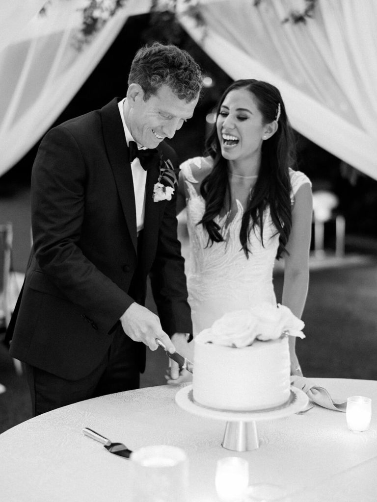 black and white image of bride and groom cutting wedding cake at Seattle wedding venue - Jacqueline Benét Photography