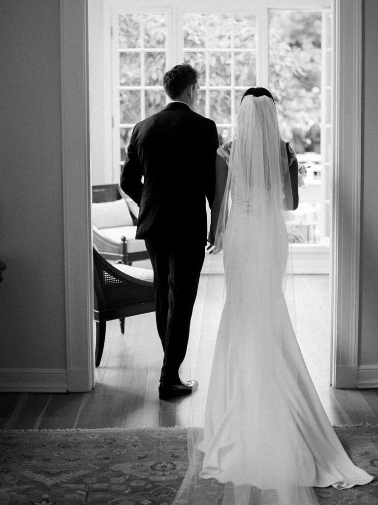 black and white photo of bride and groom walking in Admirals House - Jacqueline Benét