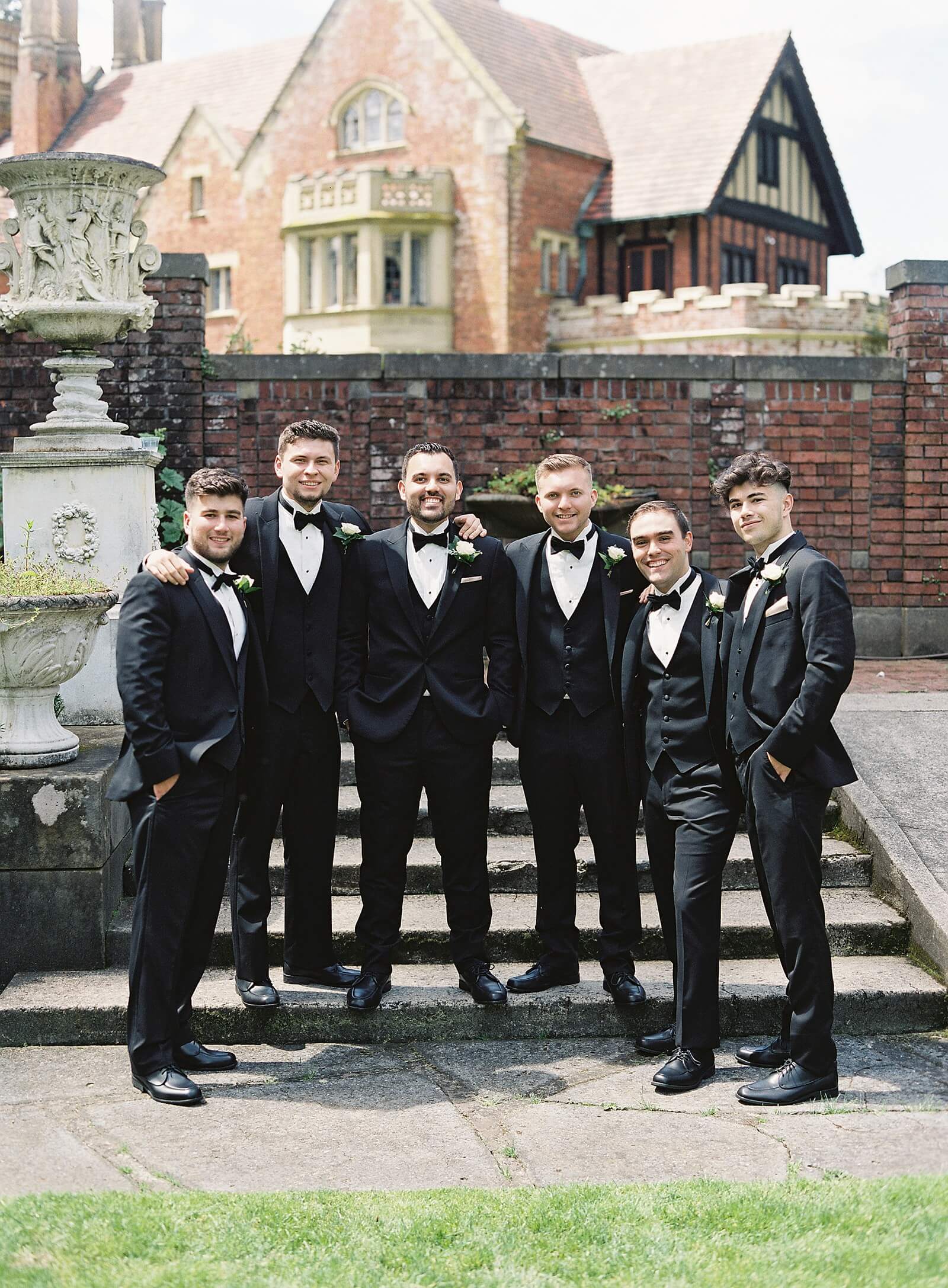 Groom and groomsmen in front of Thornewood Castle - Jacqueline Benét Photography