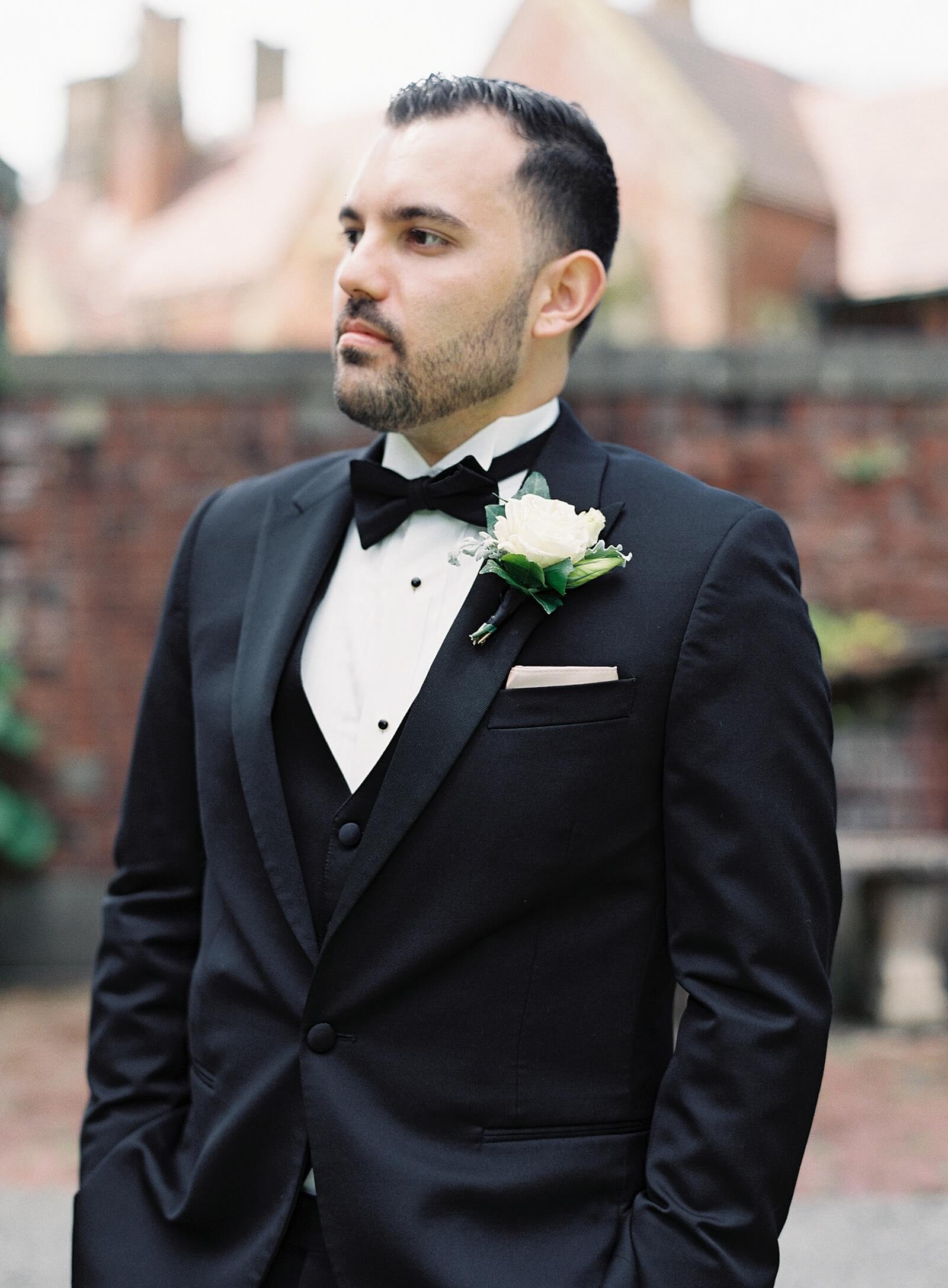 Groom in classic black tux in front of Thornewood Castle - Jacqueline Benét Photography