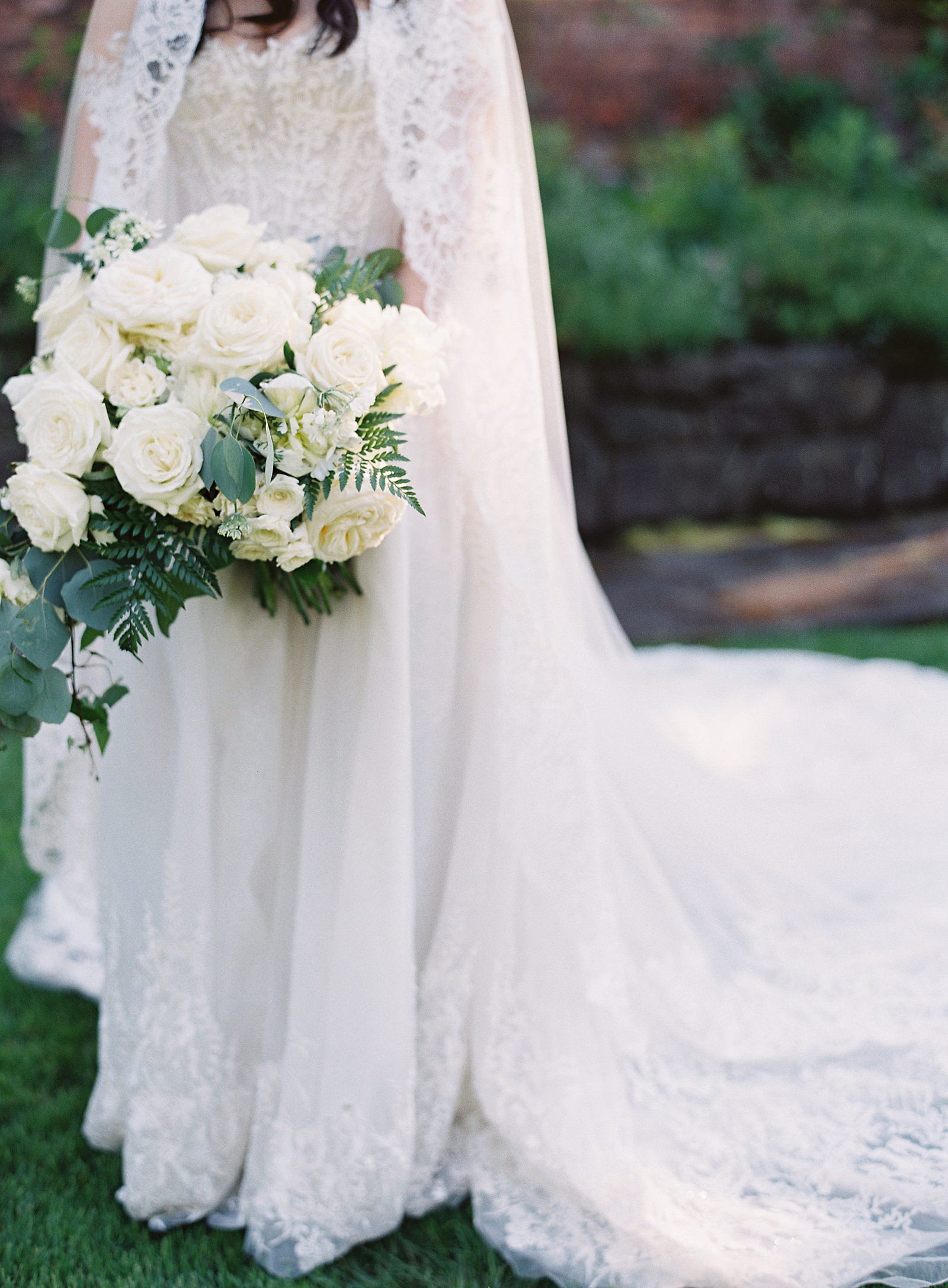White bridal bouquet with lace wedding gown and veil at Thornewood Castle garden - Jacqueline Benét Photography