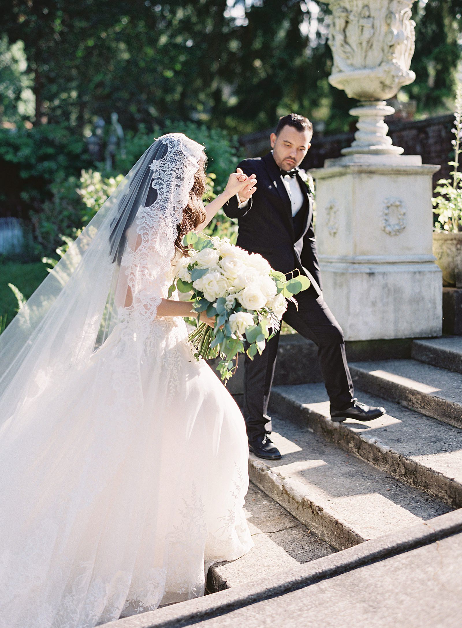 Groom escorts bride up the steps of Thornewood Castle -  Jacqueline Benét Photography