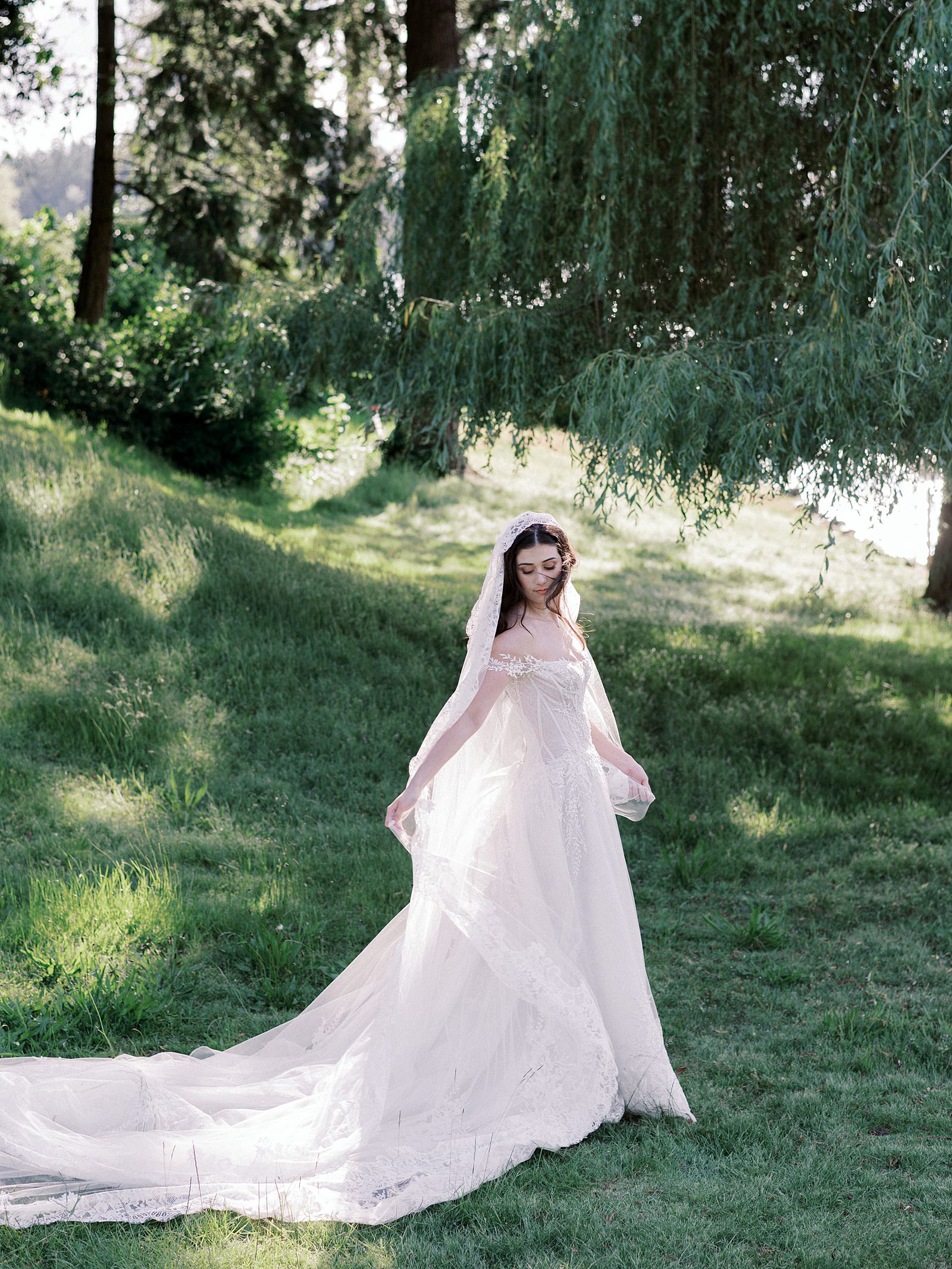 Bride in windswept portrait by the willow tree of Thornewood Castle in dramatic wedding gown - Jacqueline Benét Photography