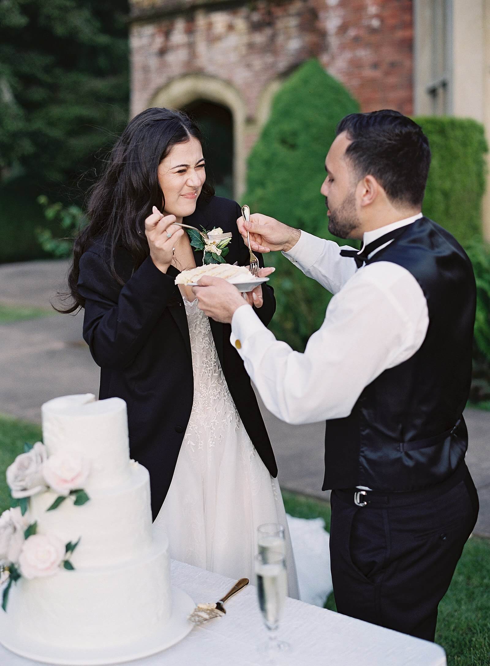 Bride and groom eating their wedding cake at Thornewood Castle - Jacqueline Benét Photography