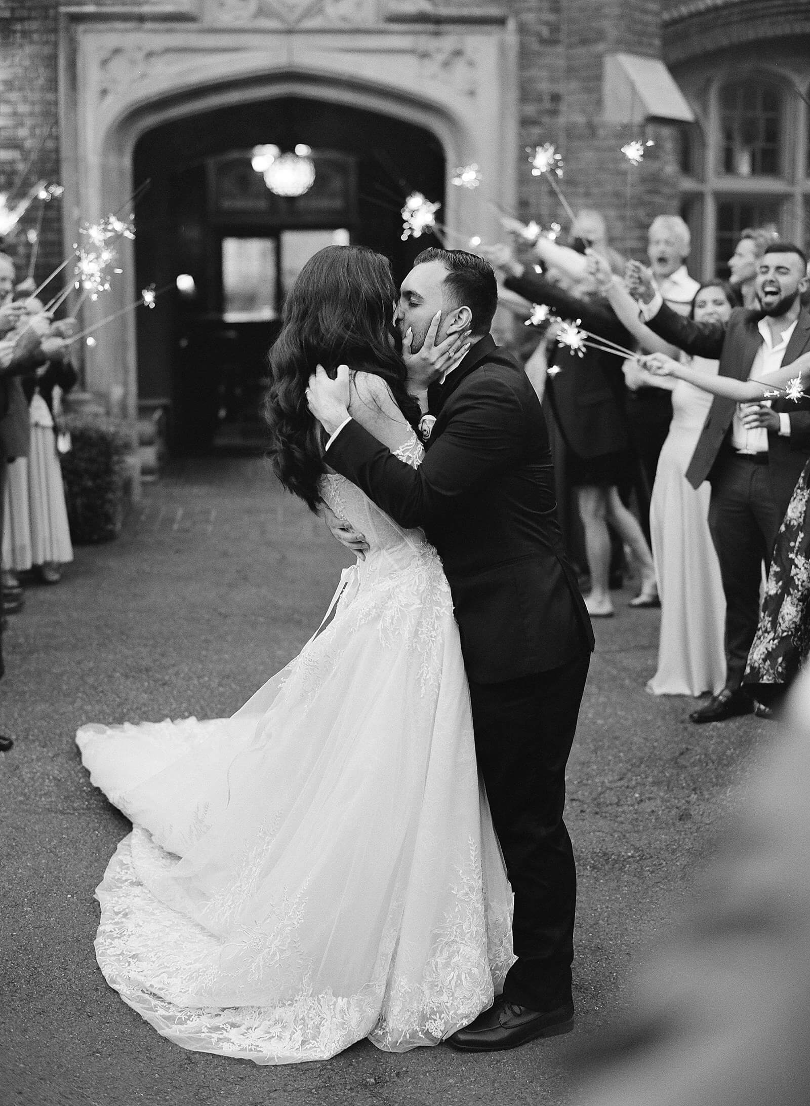 Bride and groom kiss outside Thornewood Castle during sparkler exit - Jacqueline Benét Photography