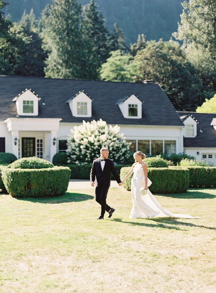 Bride and groom in classic wedding attire walk in front of Fox Hollow Farm wedding venue in Seattle - Jacqueline Benét Photography