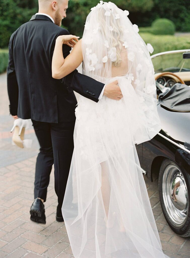 Bride and groom get into porche roadster getaway car - Jacqueline Benét Photography