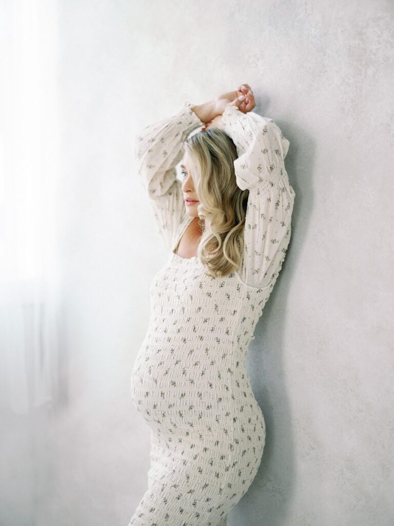 Maternity Photo in Seattle studio with pregnant woman in form fitting nothing fits but dress with long sleeves and floral pattern