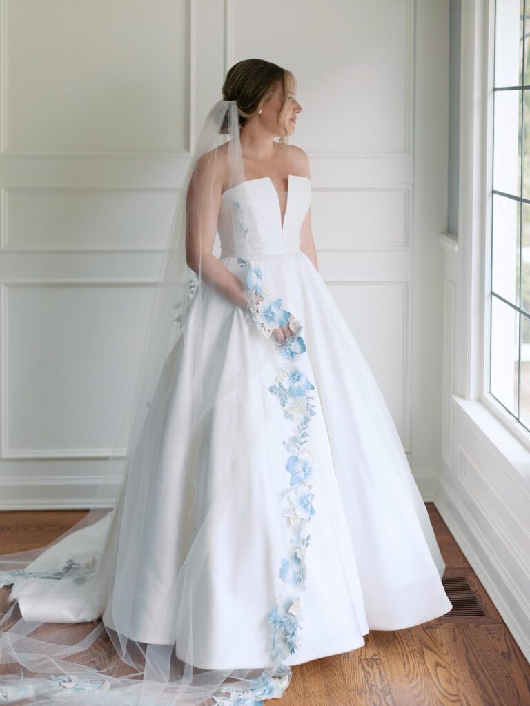 The bride smiling in her classic strapless gown with a pale-blue floral-lined train, photographed by Jacqueline Benét | Seattle wedding photographer