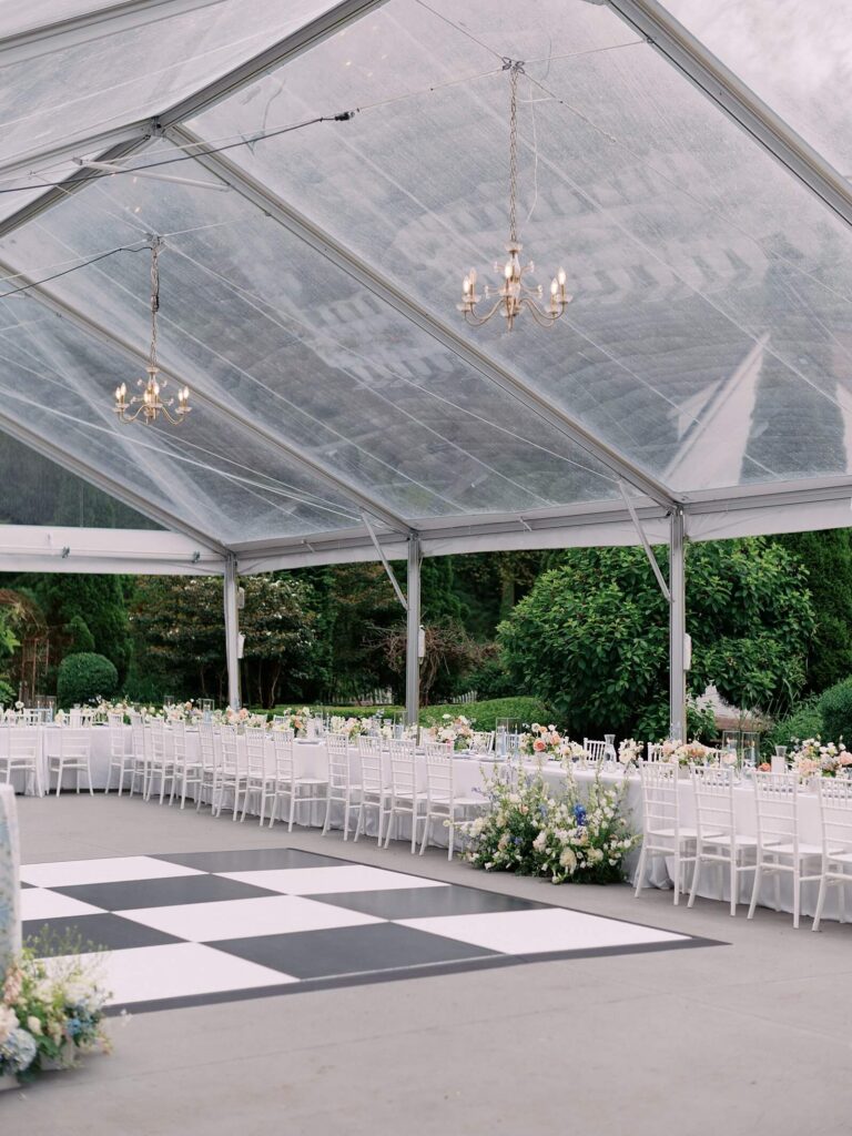 The beautiful reception set up under the tent at fox hollow farm during a garden wedding with pastel florals and a black and white checkered dance floor. Seattle wedding photography 