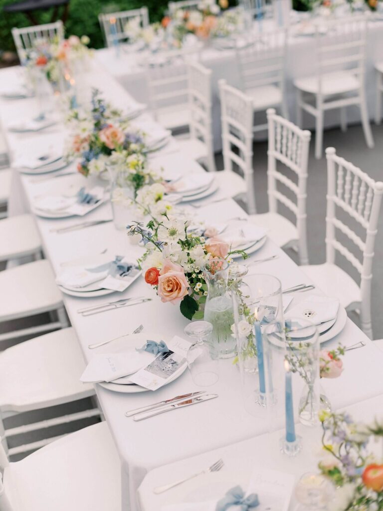 Detail photo of patterned linens, pastel florals, and elegant place settings inside the reception tent at Fox Hollow Farm, captured by Jacqueline Benét | garden wedding at Fox Hollow Farm