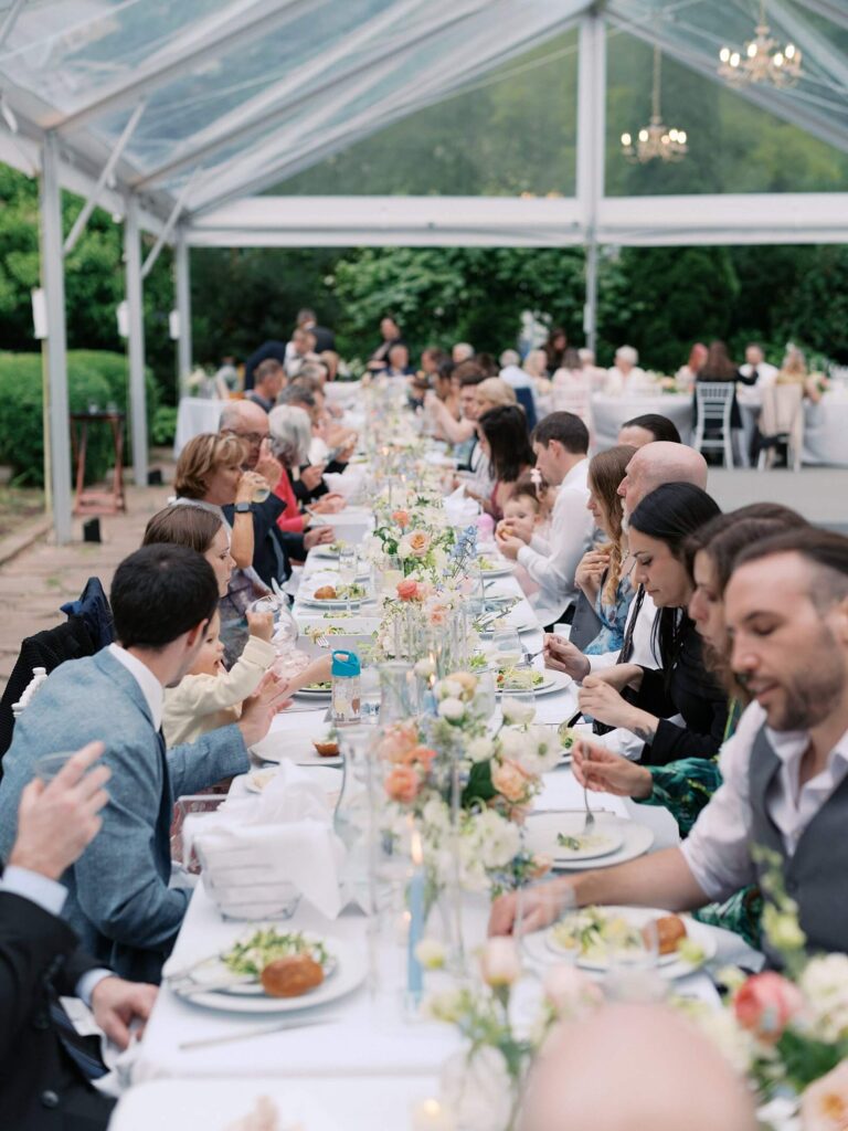 The wedding guests enjoying their meal under the reception tent during a beautiful wedding at Fox Hollow Farm - shot by Jacqueline Benét - Seattle wedding photographer 