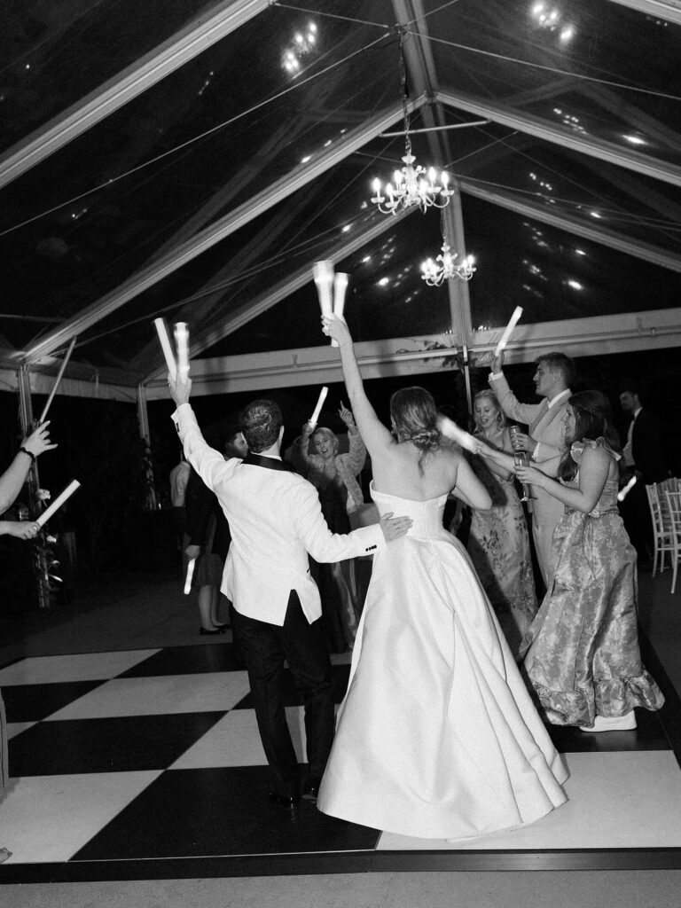 Reception tent glowing at sunset with chandeliers and a black-and-white dance floor, photographed by Jacqueline Benét | Seattle wedding photographer
