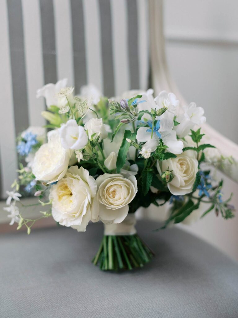 Garden floral bridal bouquet in pale cream white and pops of blue