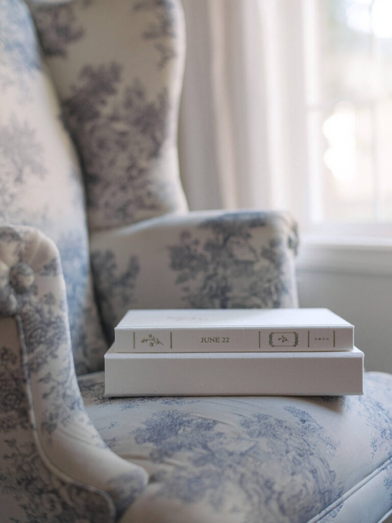 Photo of a classic, linen bound heirloom wedding photo album, resting on it's side with the spine facing the camera. Image taken by Seattle wedding photographer, Jacqueline Benét