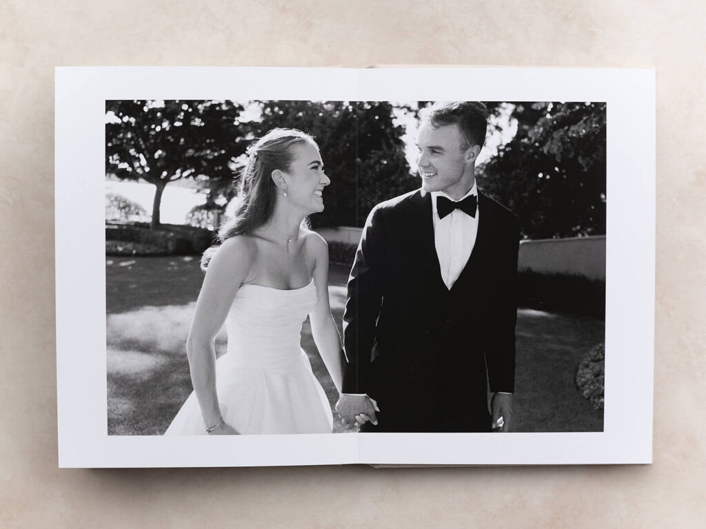 Photo of an heirloom wedding photo album opened up in the very center and showcasing a black and white portrait of a Seattle bride and groom on their wedding day. Captured by Seattle wedding photographer, Jacqueline Benét
